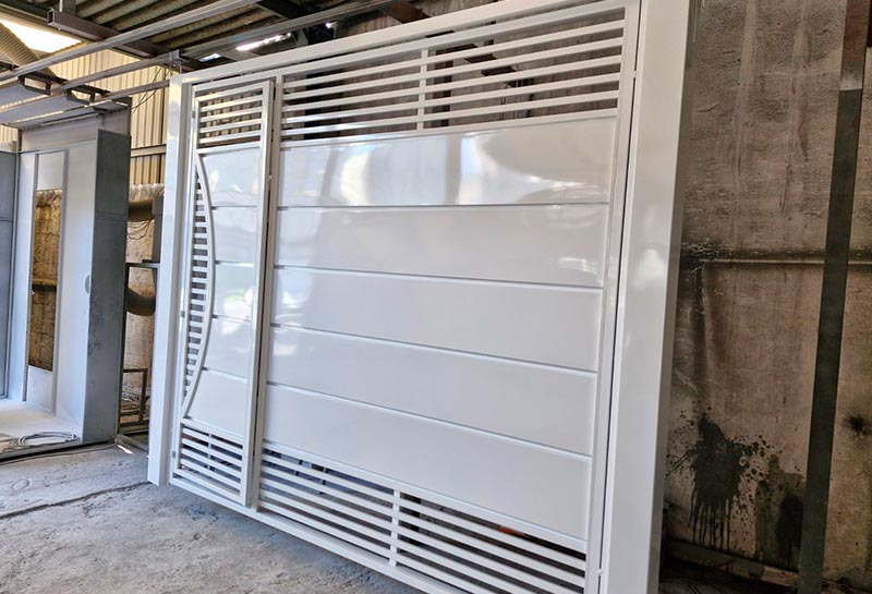 Portão de ferro pintado após remoção da tinta antiga